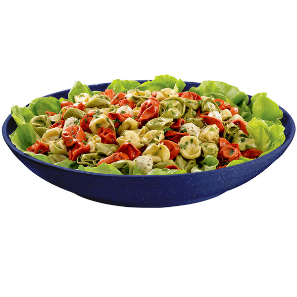 A blue speckled Tablecraft pasta bowl filled with tortellini on a bed of lettuce.