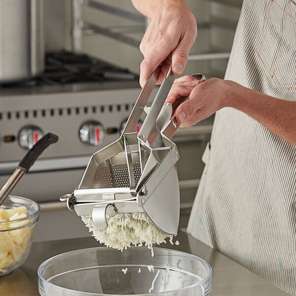 A close-up of a Thunder Group stainless steel potato ricer.