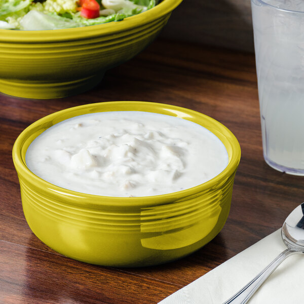 A Lemongrass Fiesta chowder bowl filled with food on a table with a bowl of salad.