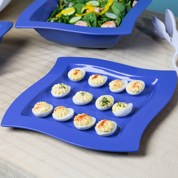 A Tablecraft blue speckle cast aluminum platter with deviled eggs and salad.