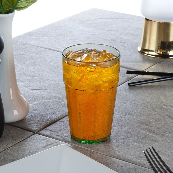 A green Thunder Group Diamond polycarbonate tumbler filled with ice tea on a table.