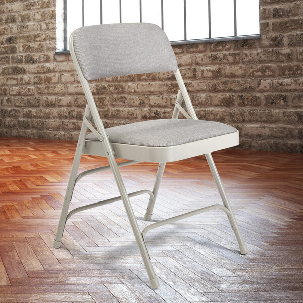 A National Public Seating gray metal folding chair with a gray padded seat.