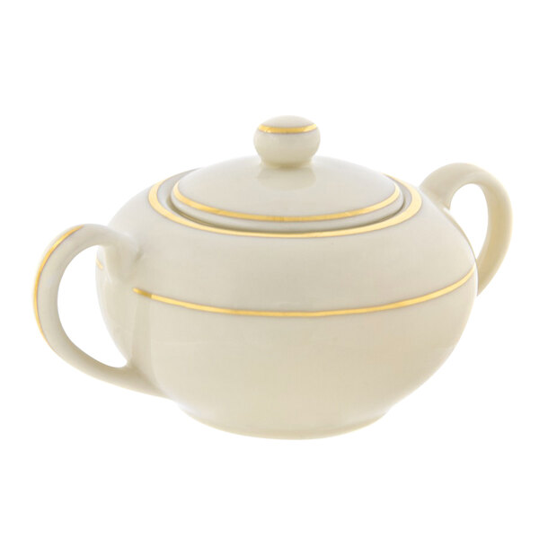 A white porcelain sugar bowl with gold stripes and a yellow line.