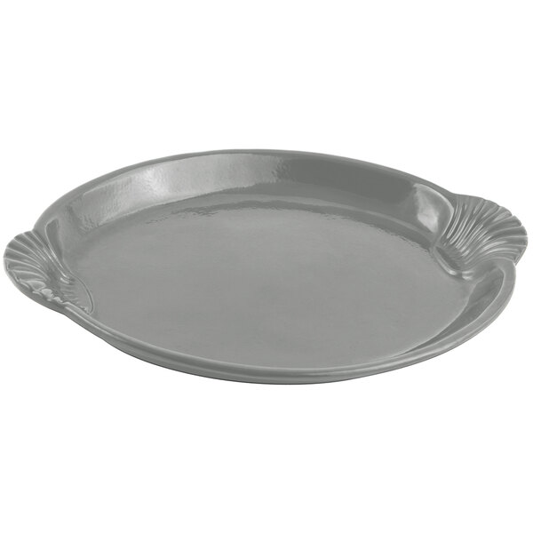 A gray cast aluminum platter with a shell and fish design.