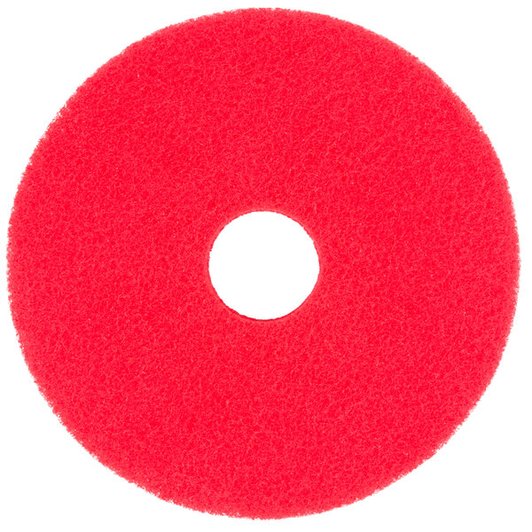 A red circular Scrubble floor buffing pad.