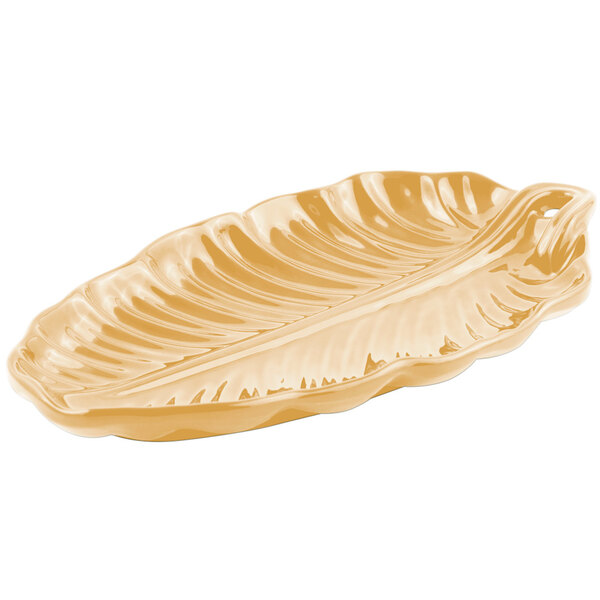 A gold Bon Chef leaf-shaped platter with a leaf pattern.