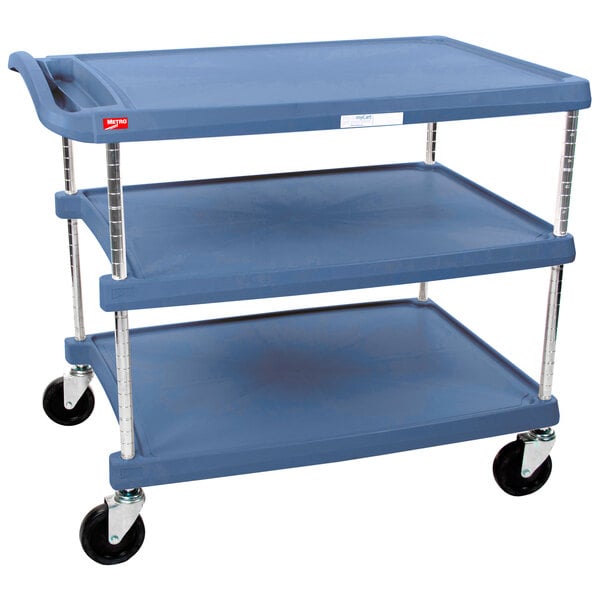 A blue plastic Metro utility cart with three shelves and black wheels.