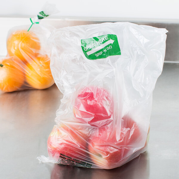 A roll of Inteplast Group plastic produce bags filled with apples and oranges.