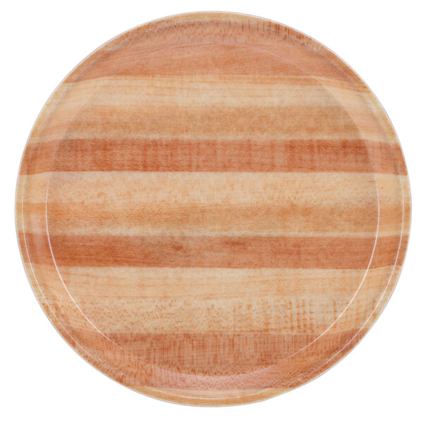 A close up of a Cambro round butcher block fiberglass tray with a striped wooden pattern.