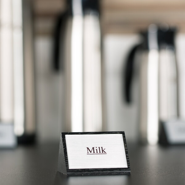 An American Metalcraft wood sign that says "Milk" on a countertop.