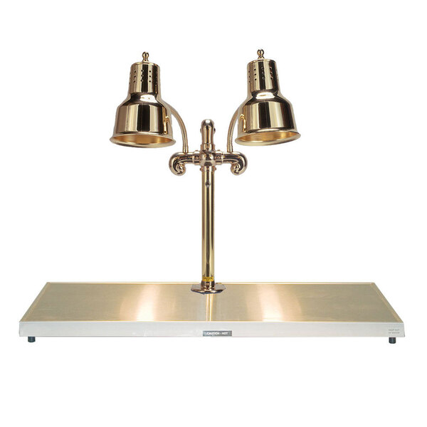 A Hanson Heat Lamps brass carving station with two lamps over a table.