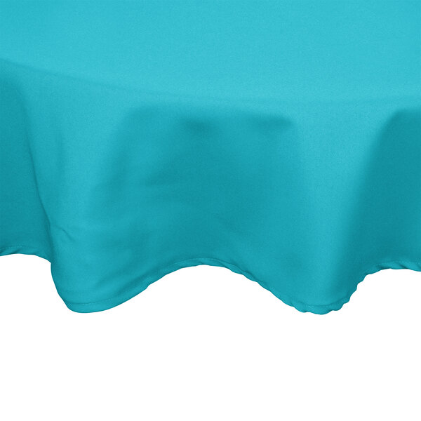 A teal Intedge round tablecloth on a table.