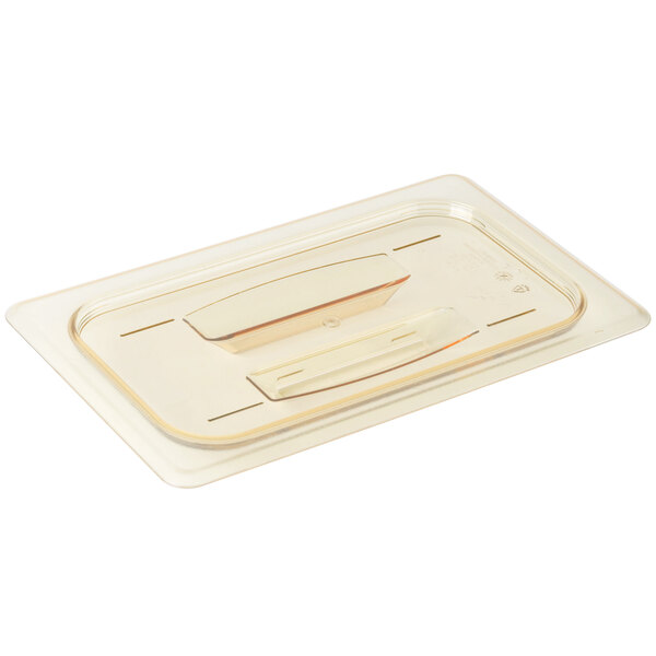 A Cambro amber plastic lid with handles on a white surface.