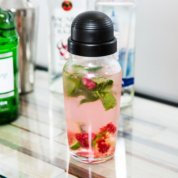 A Libbey glass cocktail shaker with a drink and fruit in it.