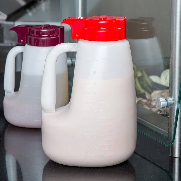A Tablecraft plastic jug with a red lid.