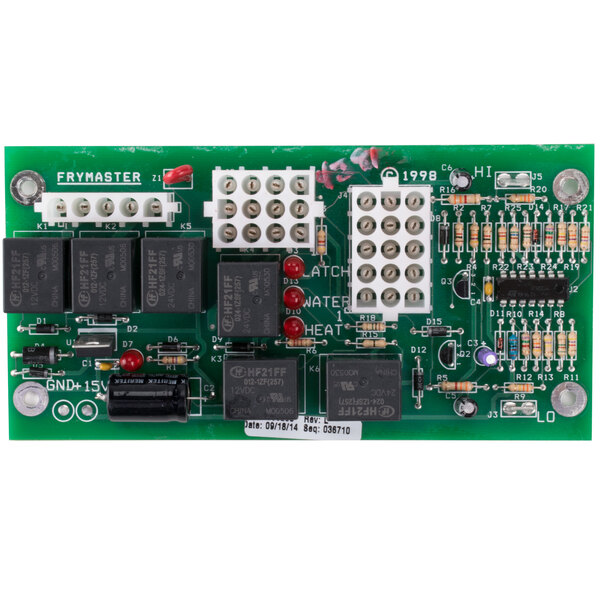 A close-up of a green Frymaster Interface Board with many small black and white electronic components.