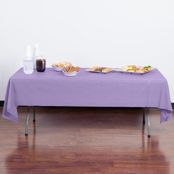 A table with food on it covered by a luscious lavender purple Creative Converting plastic tablecloth.