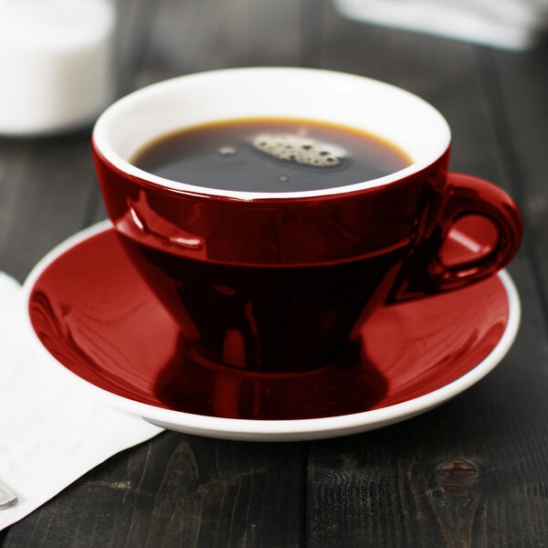 A CAC red Venice cup of coffee on a saucer.