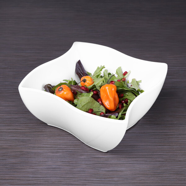 A white Elite Global Solutions square melamine bowl filled with salad and orange peppers.