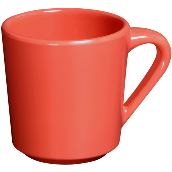 A close-up of an Elite Global Solutions Rio Spring Coral melamine mug with a red handle.