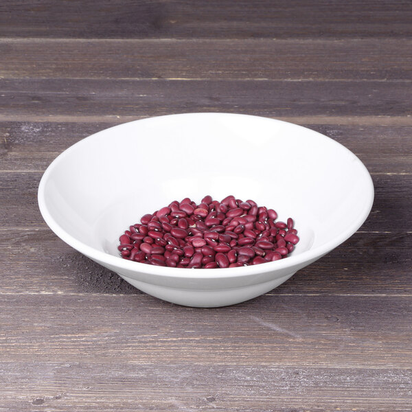 A white Elite Global Solutions melamine bowl filled with red beans on a wood surface.