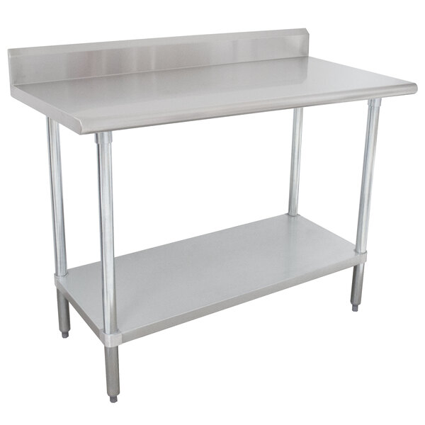 An Advance Tabco stainless steel work table with undershelf and backsplash.