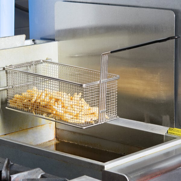 A Cooking Performance Group fryer basket filled with french fries in a countertop fryer.