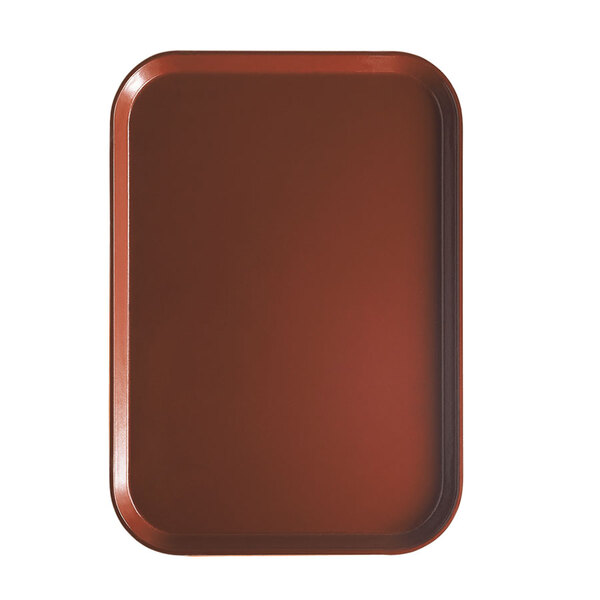 A rectangular brown Cambro tray insert with a red board on a white table.