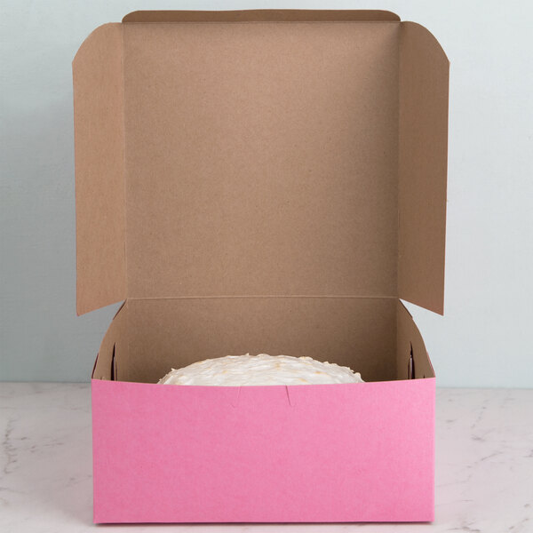 A pink box with a cake inside it.