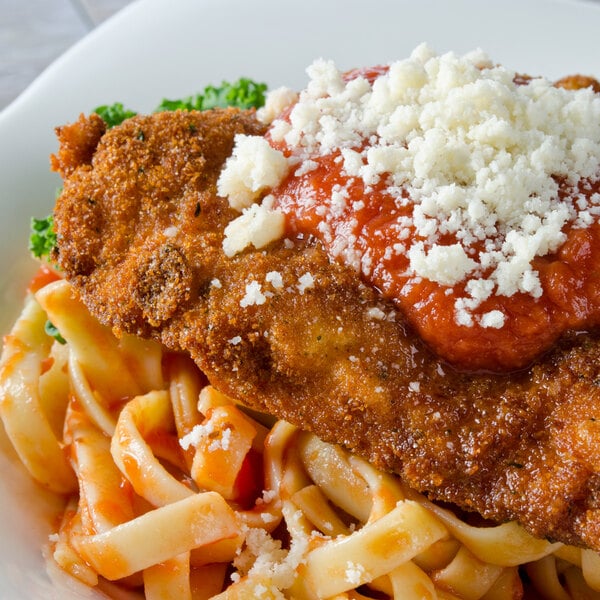 A plate of pasta with 5 lb. Italian Style Seasoned Bread Crumbs on the table.