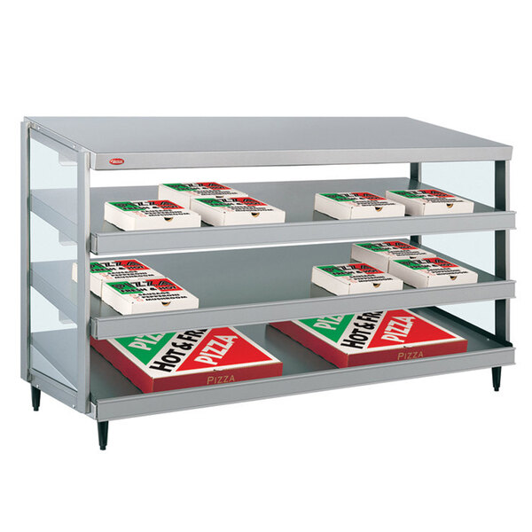 A Hatco countertop hot food display shelf with pizza boxes on it.