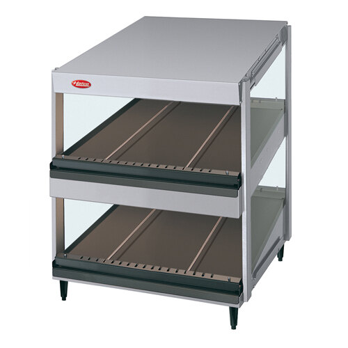 A metal shelf with slanted metal trays holding food on a white surface.