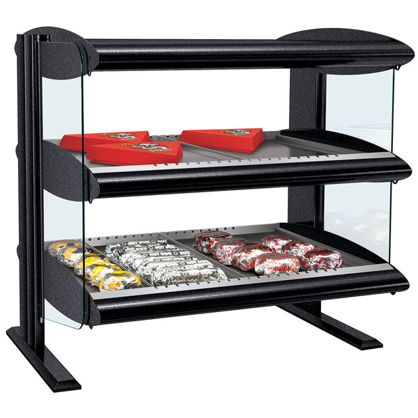 A Hatco countertop display warmer with cookies on a shelf.