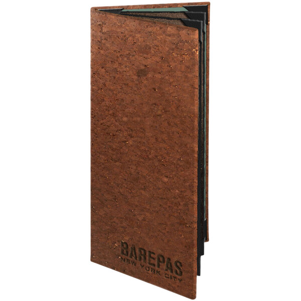 A cork menu cover with dark brown cork and black text on a brown surface.