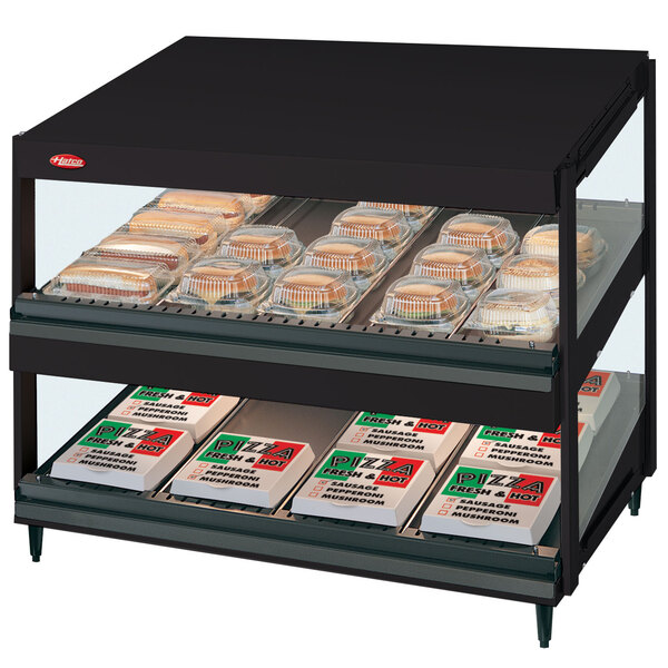 A black Hatco countertop display case with food on shelves.