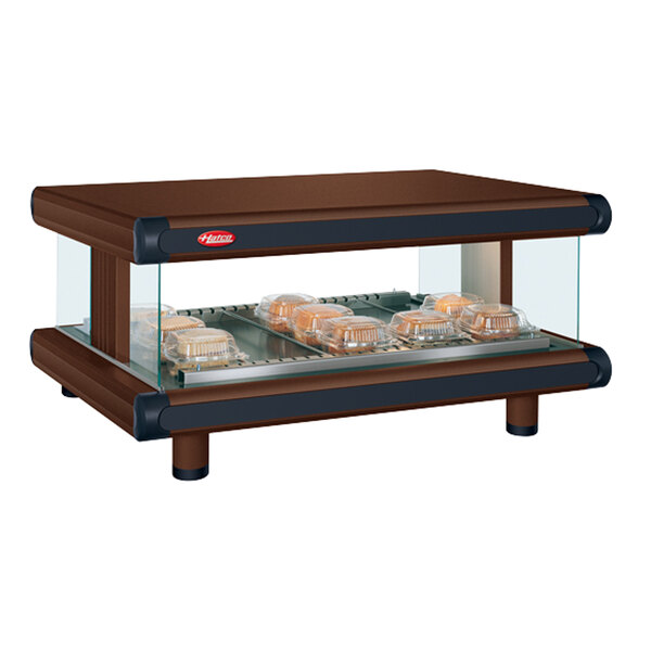 A Hatco copper countertop display rack with food in a glass display.