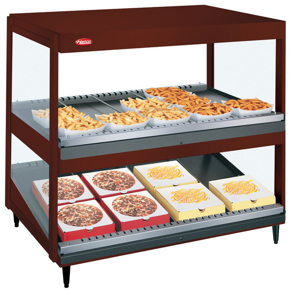 A Hatco countertop food warmer with food on shelves.