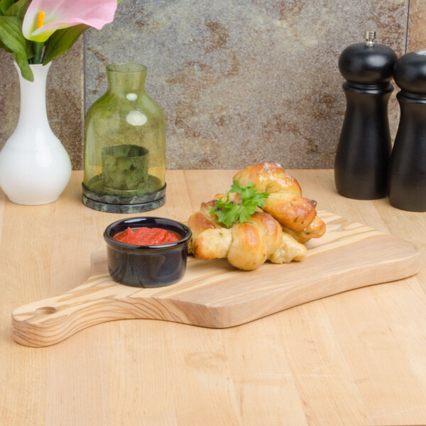 An American Metalcraft olive wood serving board with food on it.