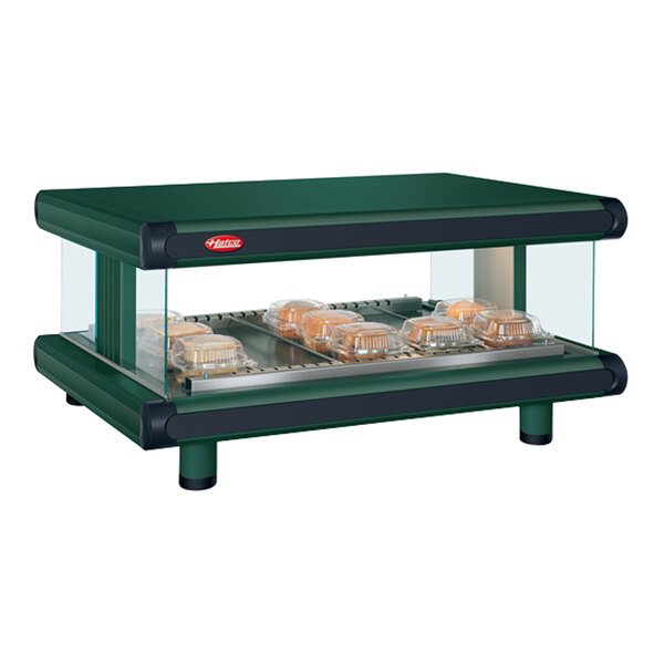 A green Hatco food warmer with trays of food.