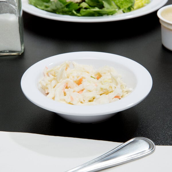 A white Thunder Group narrow rim melamine monkey dish filled with coleslaw on a table.