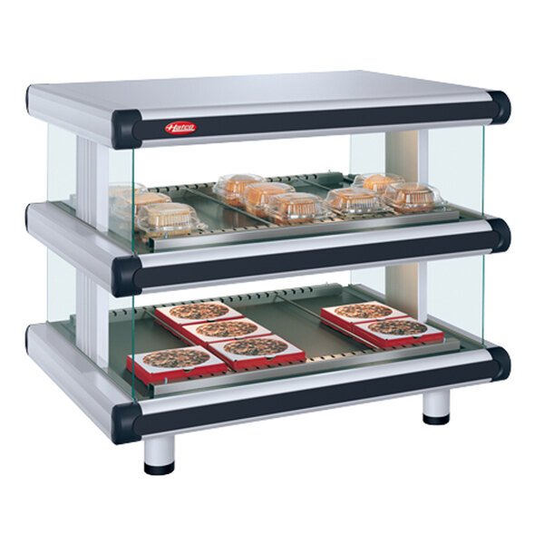 A Hatco white granite countertop food display case with food on it.