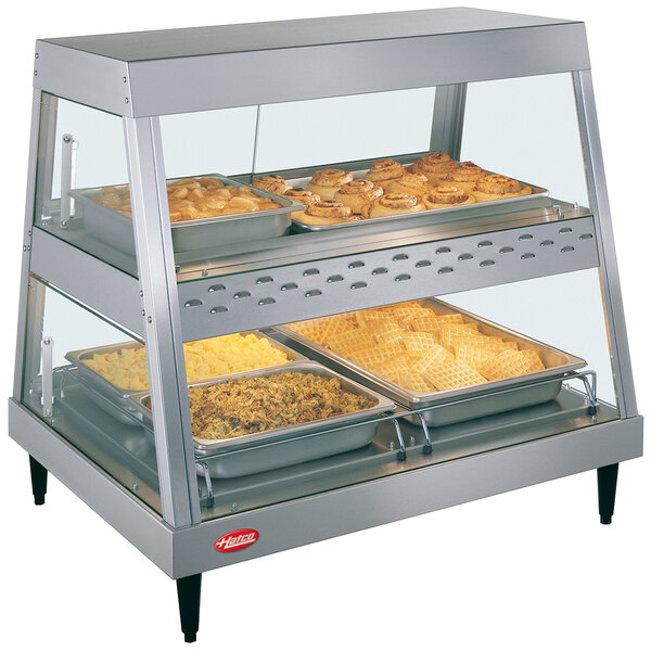 A Hatco stainless steel dual shelf countertop hot food display warmer with food displayed inside.