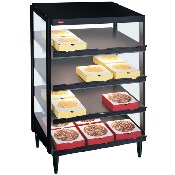 A black Hatco countertop pizza warmer with trays of pizza on shelves.