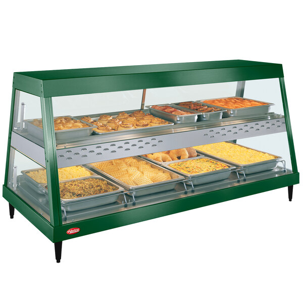 A green Hatco countertop display case with food on shelves.