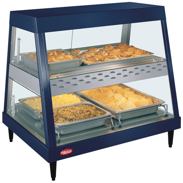 A Hatco stainless steel countertop display case with food on shelves.