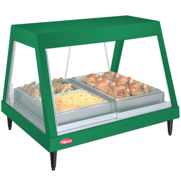A green Hatco countertop food warmer with a tray of food inside.