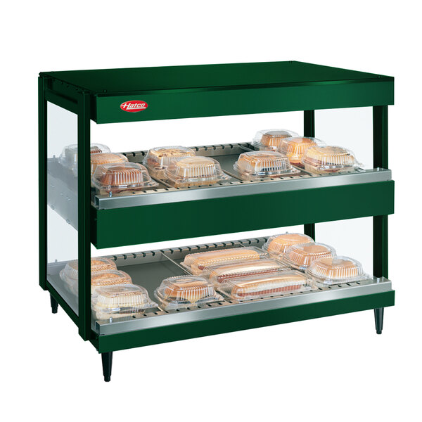 A Hunter green Hatco countertop display case with trays of food inside.