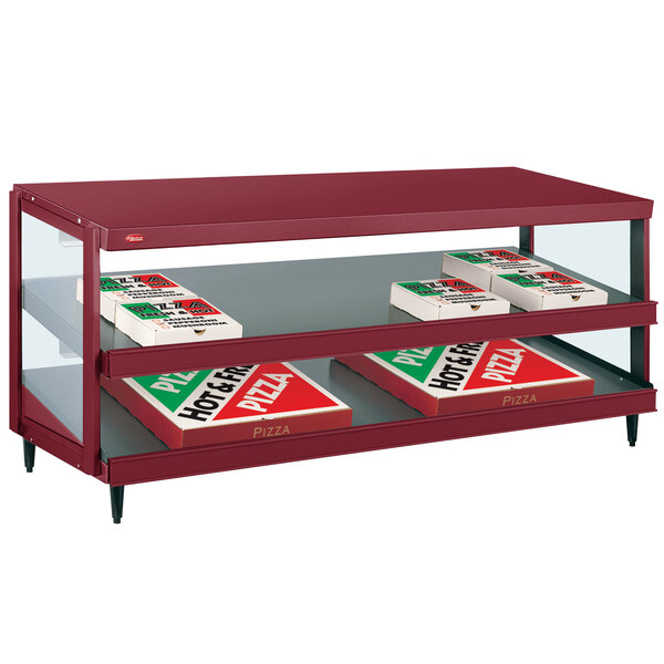 A red Hatco countertop pizza warmer with shelves of pizza boxes.