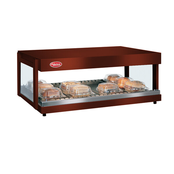 A Hatco Antique Copper horizontal shelf food warmer on a counter with trays of food inside.