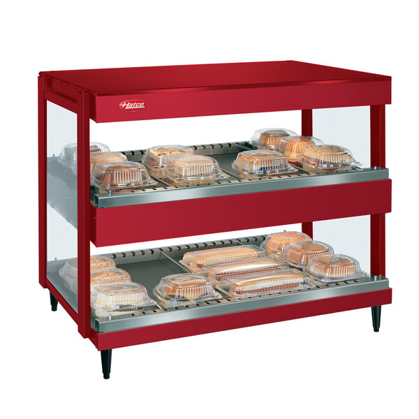 A red Hatco food cart with trays of food.